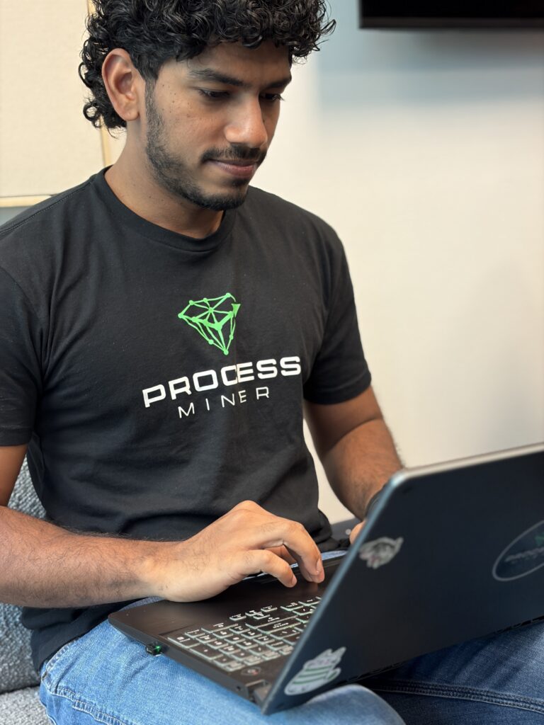 A ProcessMiner engineer working on a laptop